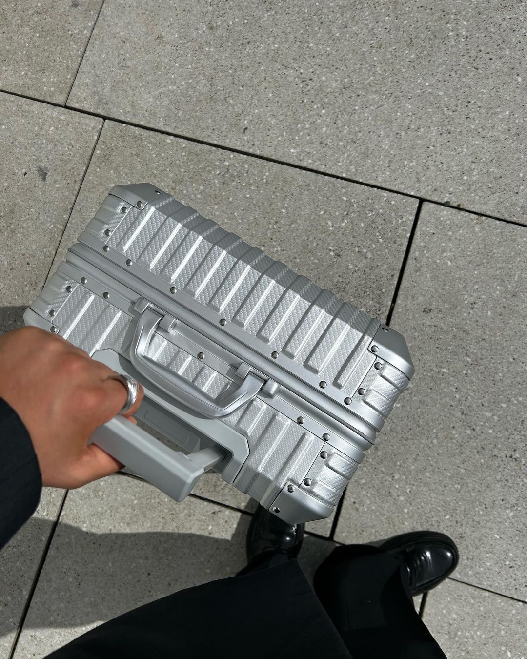 Silver aluminum suitcase with textured hard shell, sturdy handle, and premium design, ideal for business trips, luxury travel, and frequent flyers.